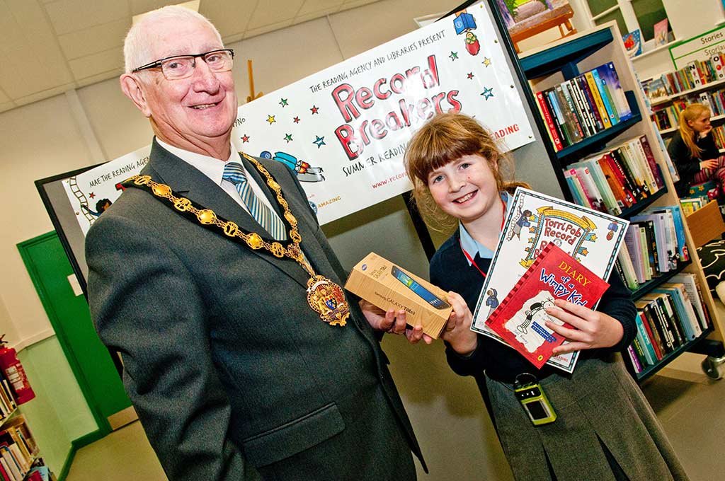 Monmouthshire Chairman Cllr Brian Strong presents Emily Agutter with her Reading Challenge prize at the Usk Community Hub